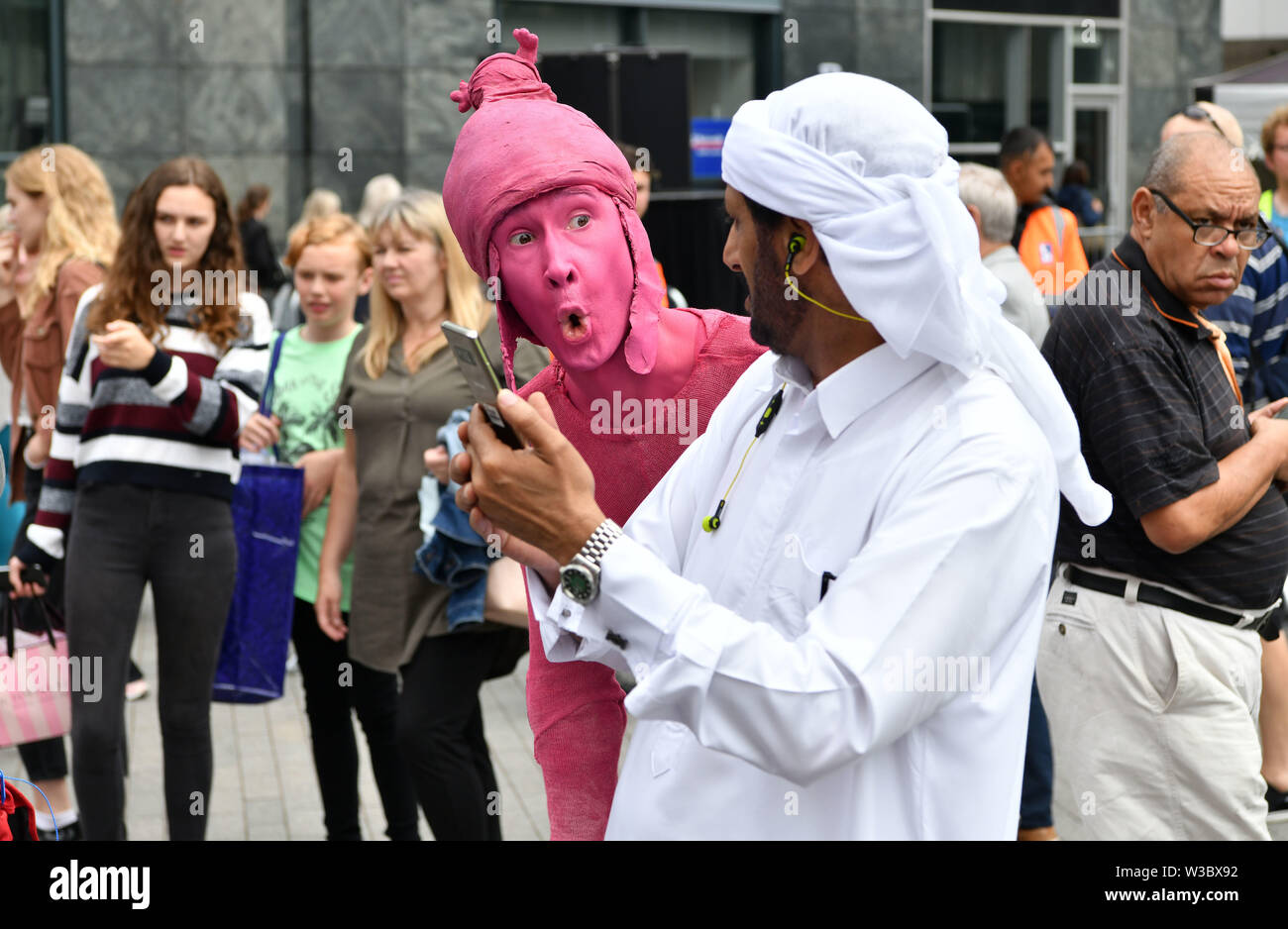 Straßenkünstler mischen sich mit den Mitgliedern der Öffentlichkeit im Bullring-Gebiet von Birmingham. Auftritte waren Teil des jährlichen Sommers im Southside Arts Festival. Stockfoto