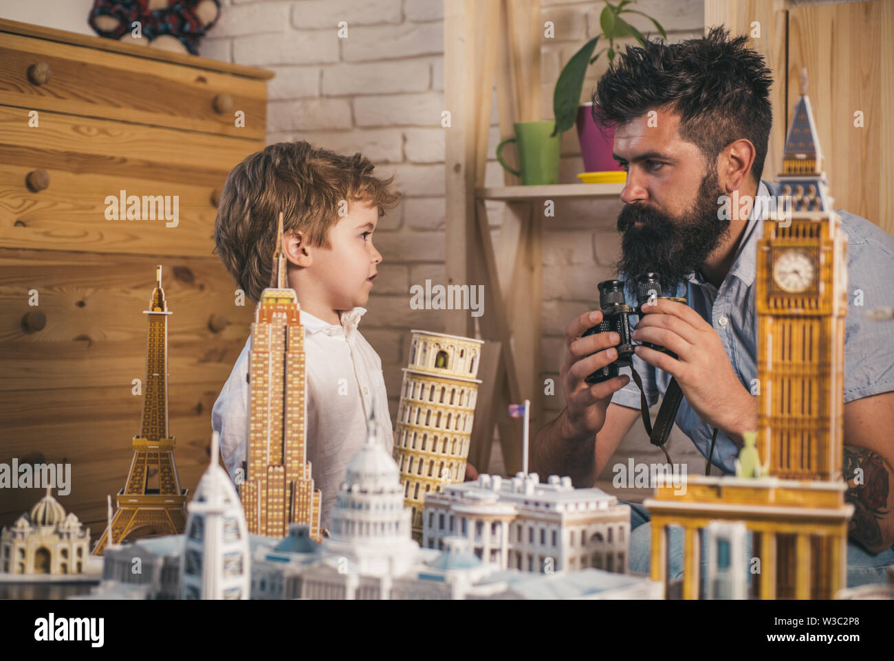 Abenteuer gleich jetzt beginnen. Die Entdeckung neuer Orte. Kind und Mann mit binokularen und Miniatur Architektur. Junge Sohn und Vater mit Welt landm Stockfoto