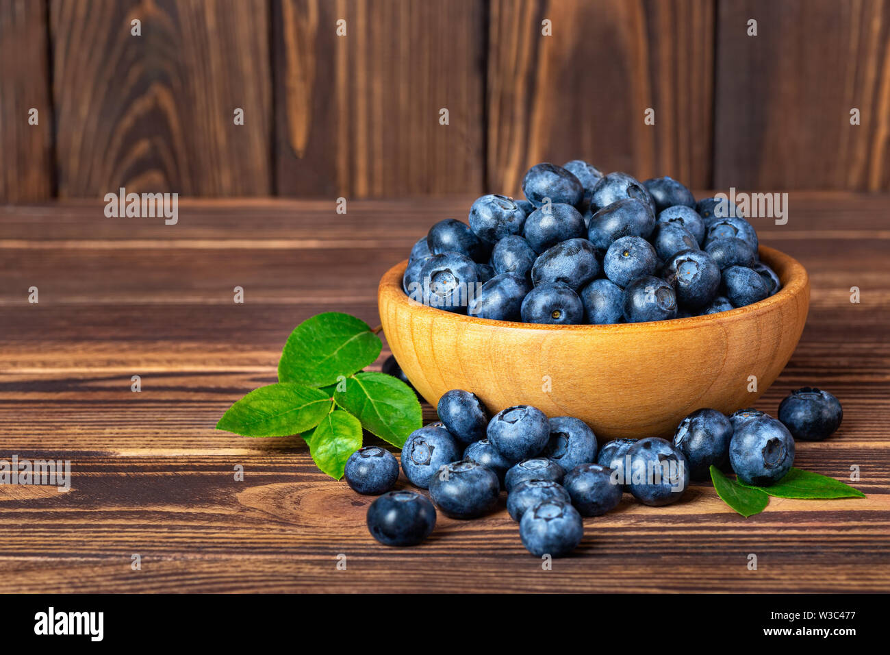 Frische Heidelbeeren in Schale auf Holztisch Stockfoto