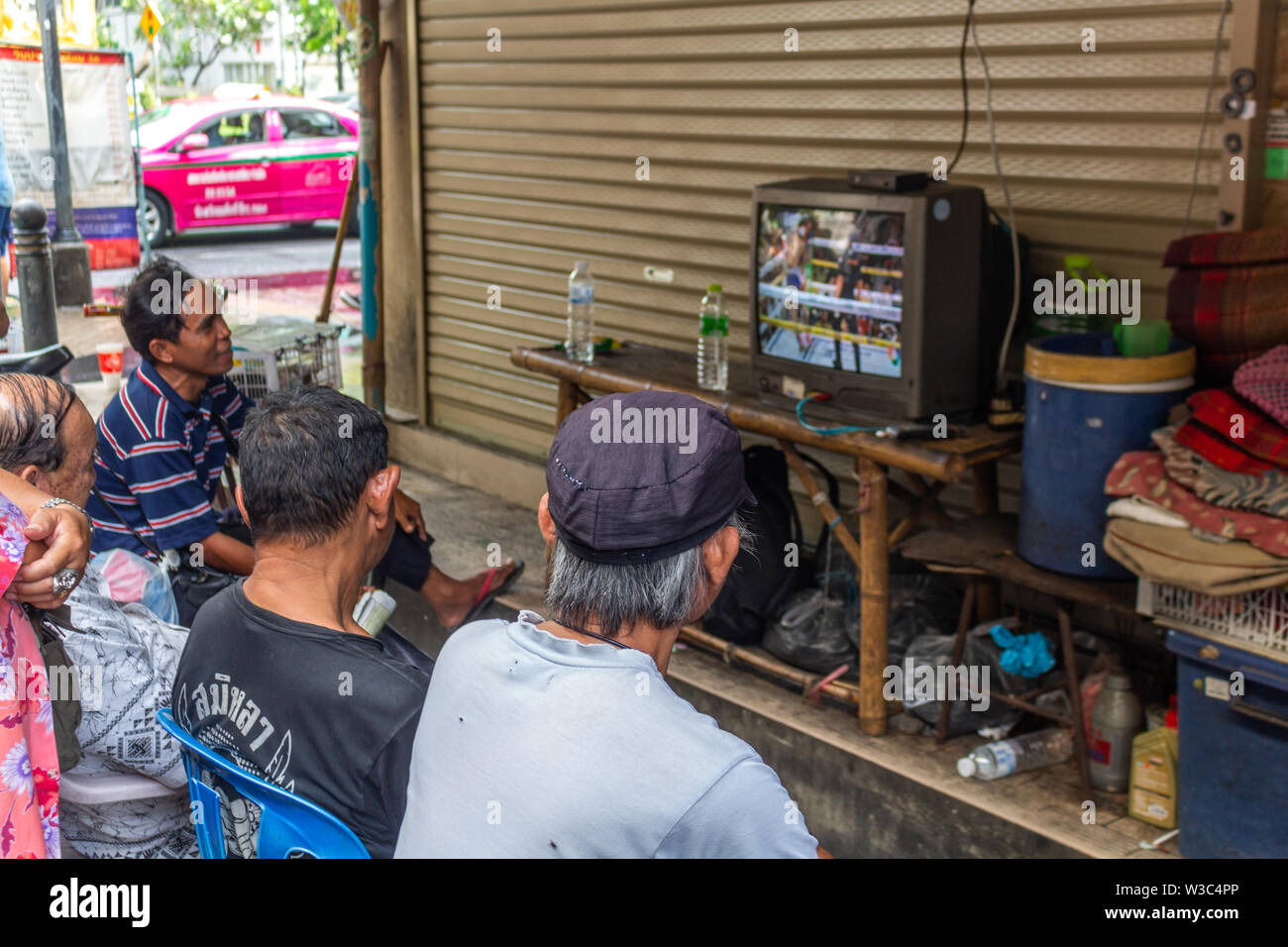 Bangkok, Thailand - 14 April, 2019: Lokale Menschen Sport im TV auf der Straße Stockfoto