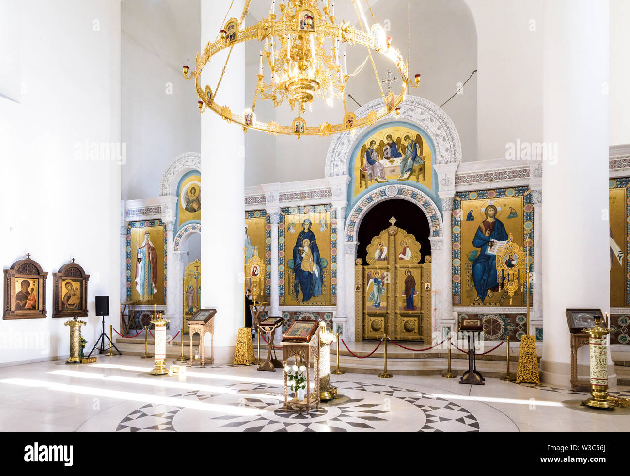 Das Kirchenschiff der Kathedrale der Heiligen Dreifaltigkeit der russisch-orthodoxen Kirche in Paris ist klein, mit einem Kronleuchter und weiße Wände mit goldenen Fresken geschmückt Stockfoto