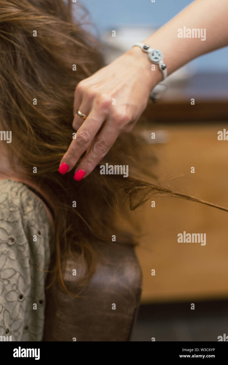 Erstellen Frisuren auf Braun braunes Haar im Salon. Erstellen Locken beim Friseur. Stockfoto