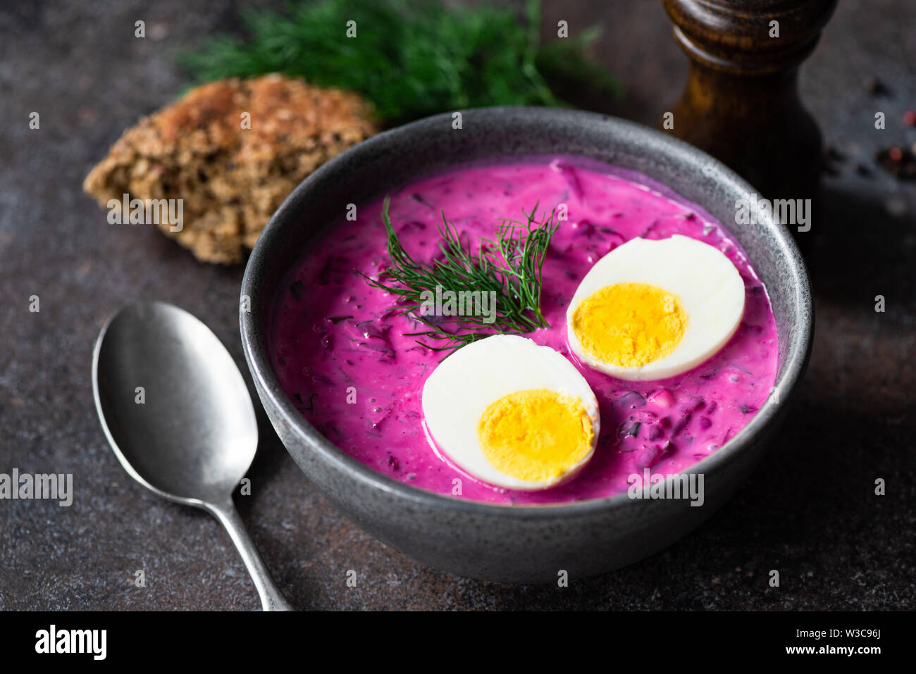 Leckere kalte Rote-Bete-Suppe mit gekochtem Ei in eine Schüssel geben. Russische, polnische Küche Stockfoto