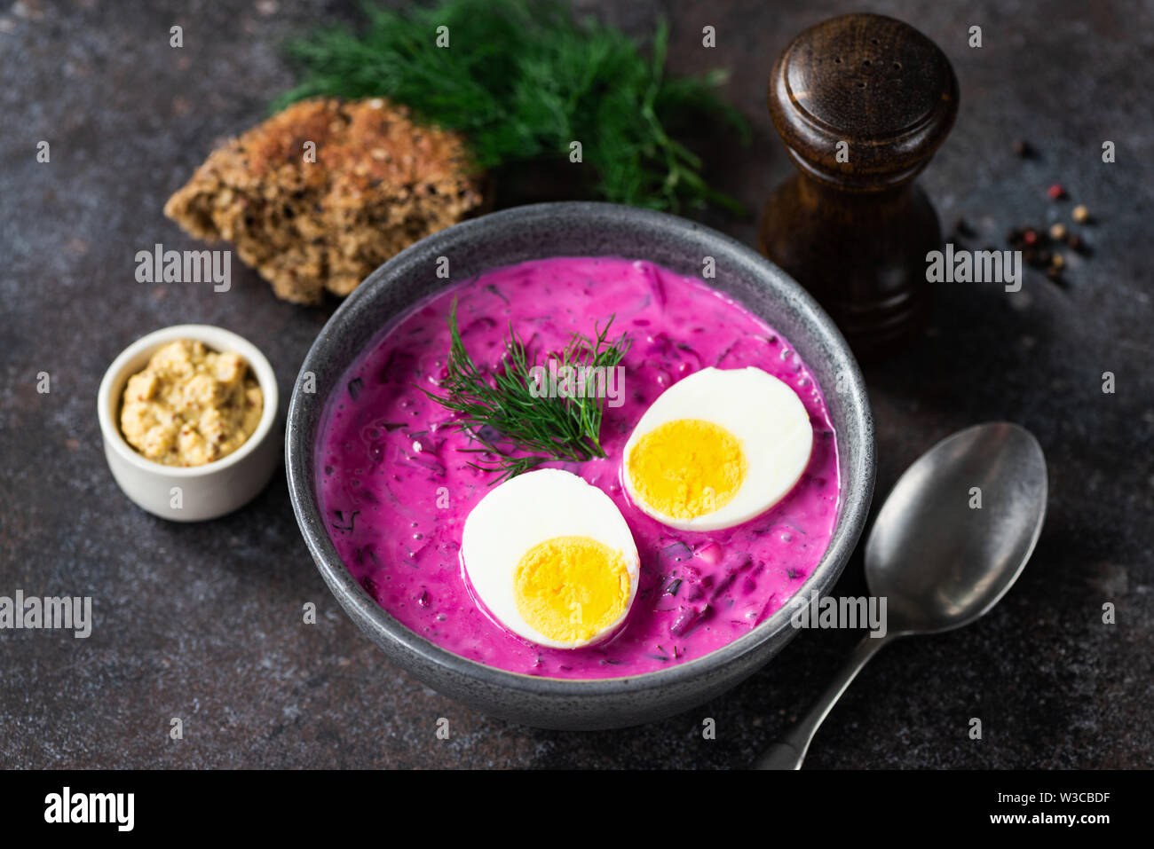 Kalte Rote-Bete-Suppe mit gekochtem Ei in Keramik Schüssel auf dunklem Hintergrund Stockfoto