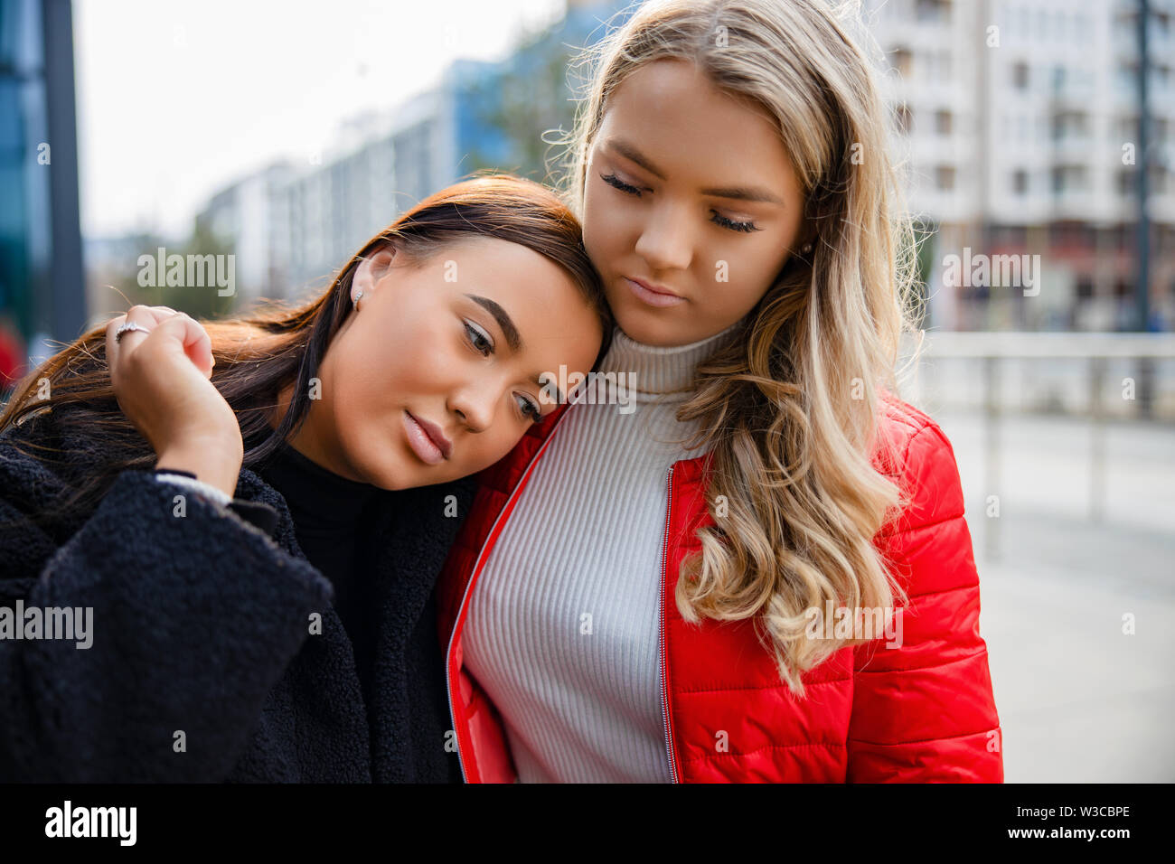 Pflege Freund trösten unglückliche junge Frau in Stadt Stockfoto