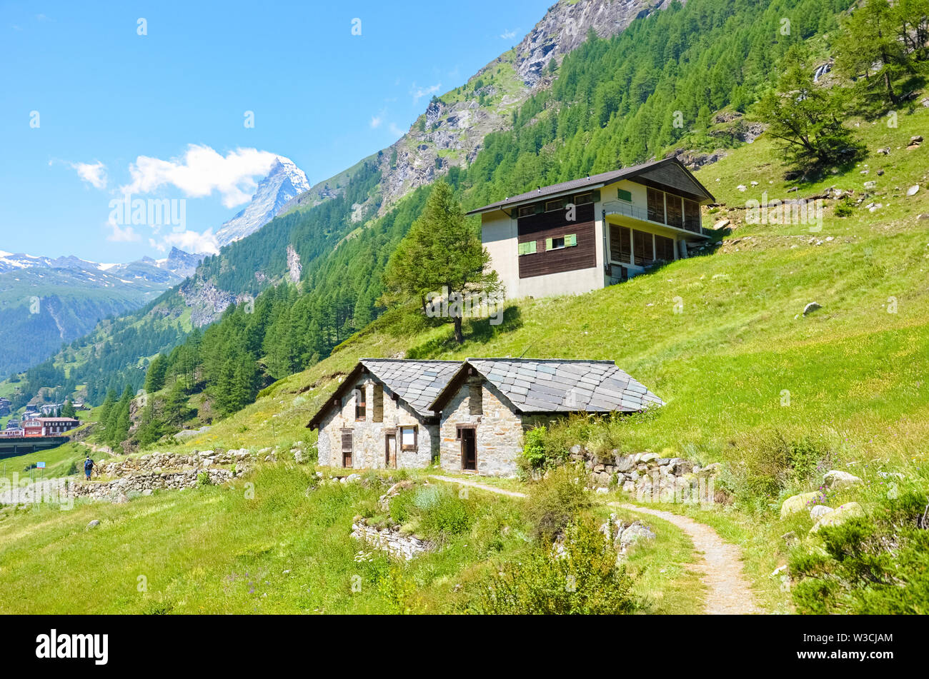 Schöne ländliche Häuser in den Schweizer Alpen in der Nähe von Zermatt, Schweiz. Berühmte Matterhorn im Hintergrund mit Schnee auf der Oberseite. Sommer Alpine Landschaft. Landschaft. Schöne Natur. Reiseland. Stockfoto