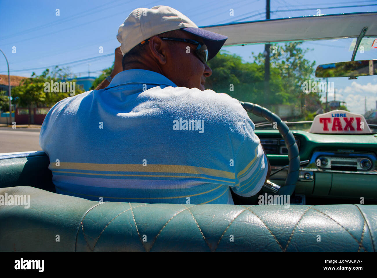 Varadero - Kuba/11. Oktober 2011, Kubanische Taxifahrer in seiner klassischen amerikanischen Cabrio nimmt Touristen zurück zum Hotel Stockfoto
