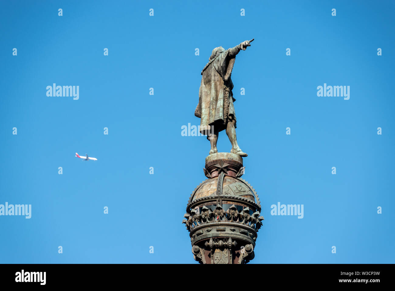 Mirador de Colom, eine Statue von Christopher Columbus dedizierte mit einem Passagier Jet fliegen durch Stockfoto