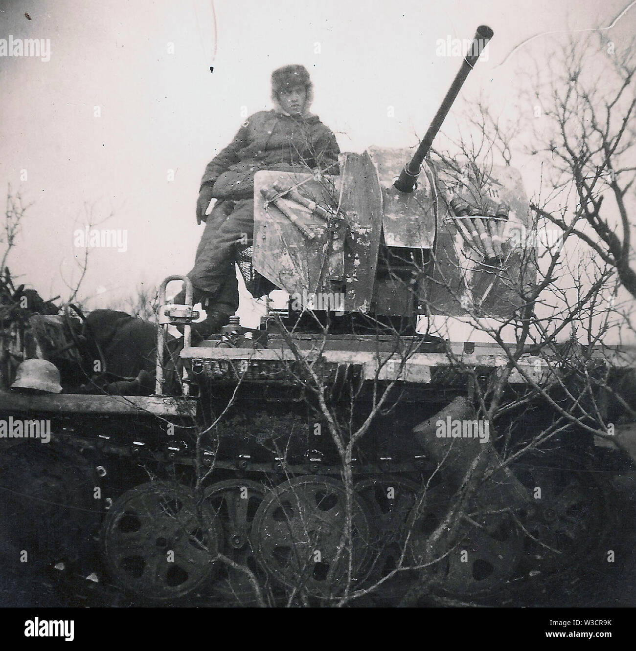 Deutscher Soldat in schwerer Winterkleidung auf einem mobilen Leichtflakfahrzeug an der Russischen Front 1943 . Ein privates Schwarzweiß-Foto des Zweiten Weltkriegs Stockfoto
