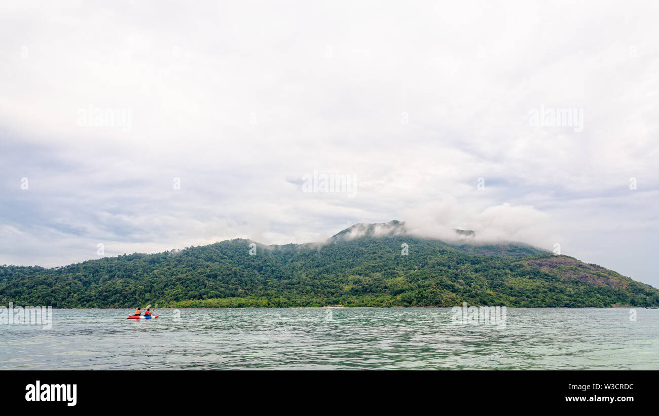 Zwei Touristen sind Kajakfahren im Meer, durch die schöne Natur am Morgen mit Wolken und Nebel, die Ko Adang Insel umgeben ist der Hintergrund, Ta Stockfoto