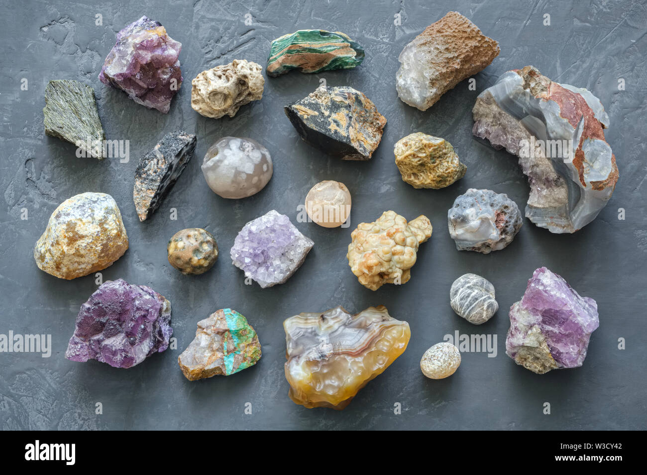 Mineral Steine Sammlung: Türkis, morion, Rauchquarz, Bergkristall, Chalcedon, Achat, Amethyst, Onyx, Chalcedon auf grauem Beton Hintergrund. Zu Stockfoto