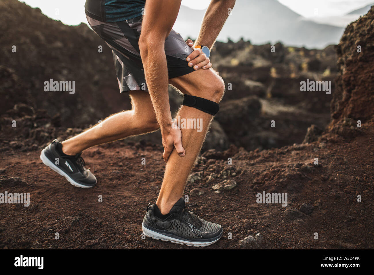 Läufer mit Knie Stützverband, haben aber ein Problem mit der Wade Muskel  auf ausgeführt wird. Beinverletzung Stockfotografie - Alamy