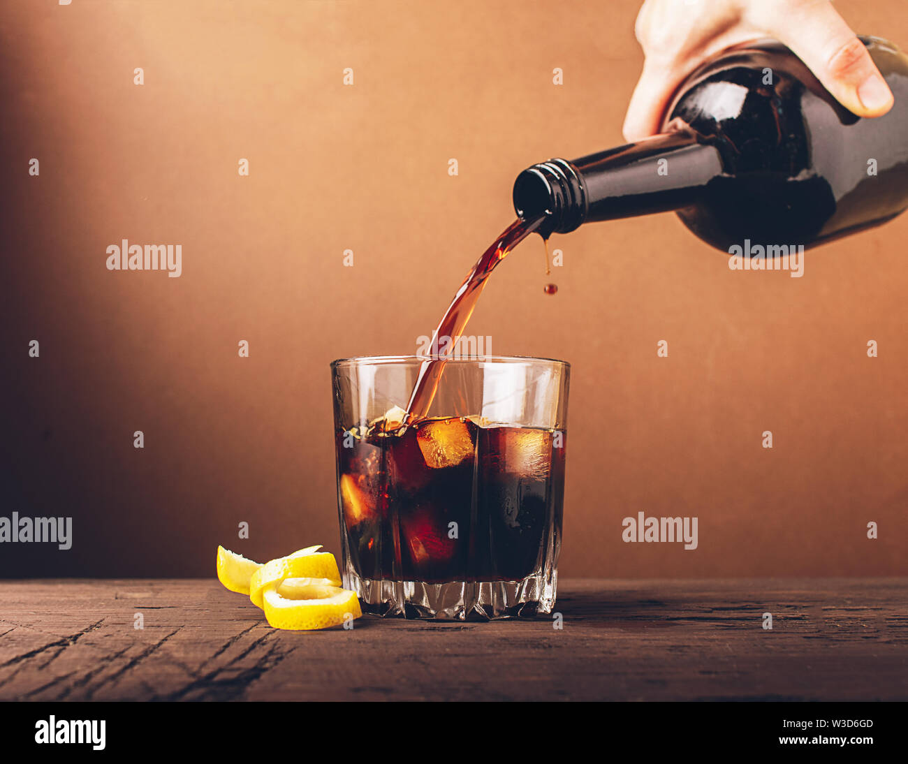 In ein Glas mit Eiswürfel gegossen Whiskey Brandy. Starke alkoholische Getränk auf einem dunklen Hintergrund. Selektive konzentrieren. Kopieren Sie Platz. Stockfoto