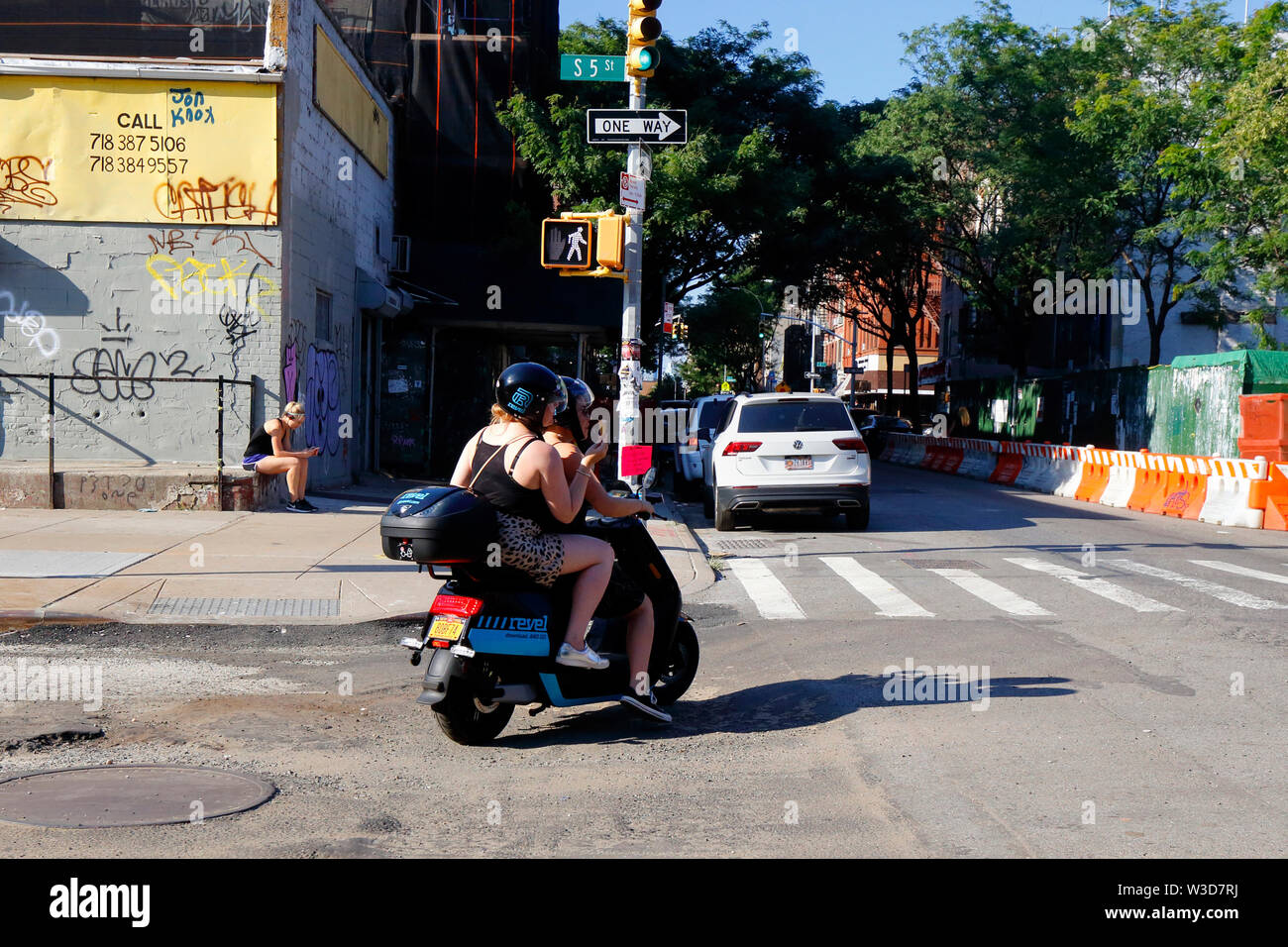 Zwei Frauen, ein essen ein Eis, reiten ein dockless Miet Moped von App-basierten Revel Transit Stockfoto