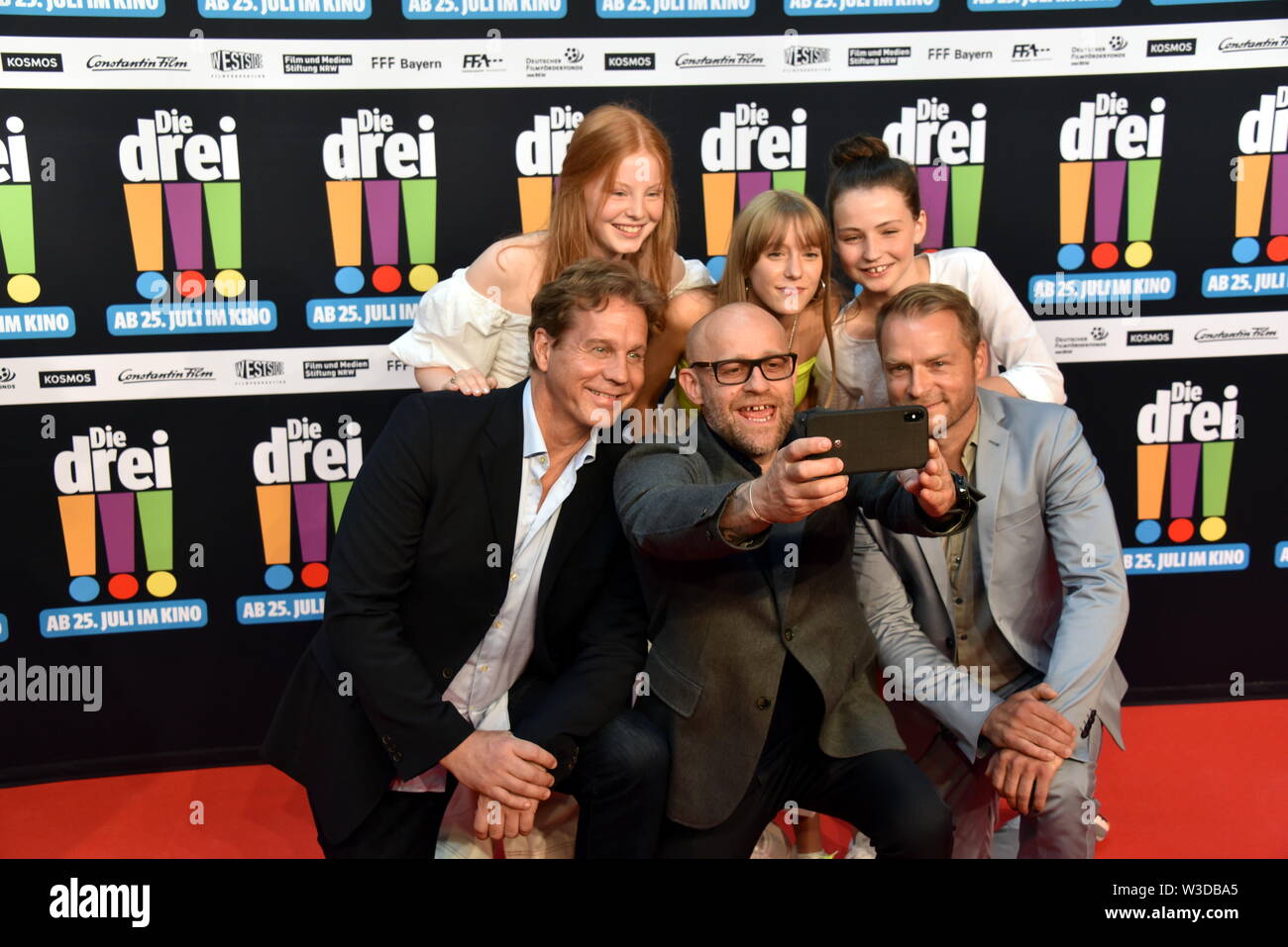 Köln, Deutschland. 13. Juli, 2019. Die Schauspieler Alexandra Petzschmann, Paula Renzler und Lilli Lacher (L-R) vor Thomas Heinze, Jürgen Vogel, Hinnerk Schönemann kommen zur Premiere des Films sterben Drei!!! (Drei Ausrufezeichen) Quelle: Horst Galuschka/dpa/Alamy leben Nachrichten Stockfoto