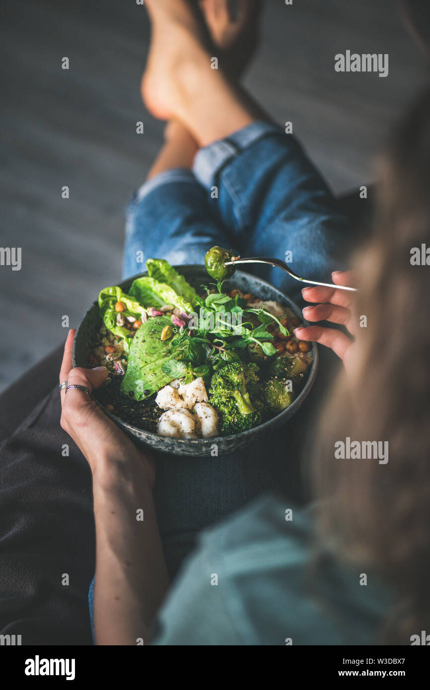 Frau zu Hause sitzen und essen vegan superbowl Stockfoto