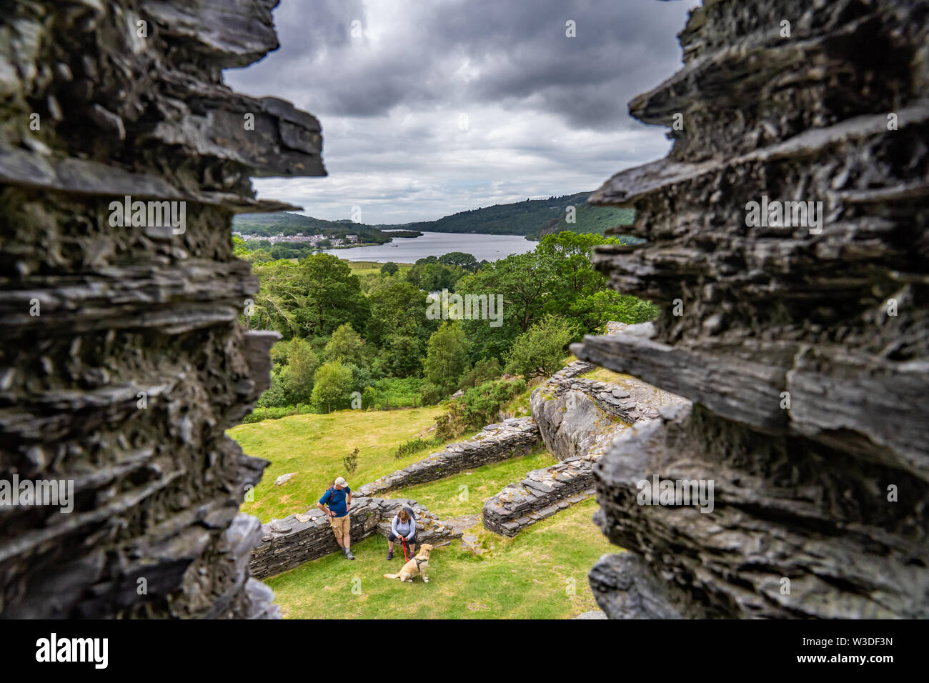 Zwei Touristen, und ihr Hund, genießen eine Reise rund um den historischen Ruinen von Dolbardan Schloss, Llanberis, North Wales Stockfoto