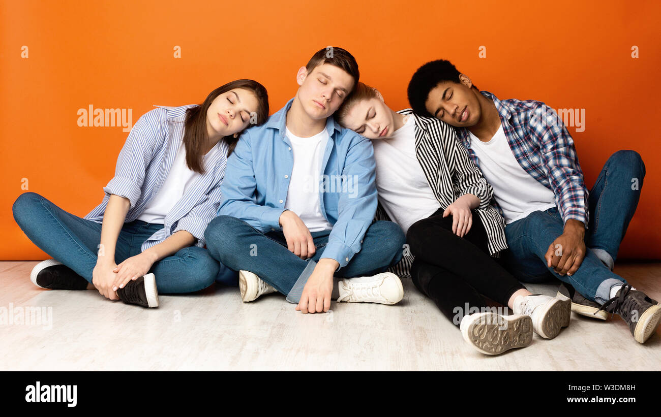 Müde Schule Freunde schlafen auf Schultern, orange Hintergrund Stockfoto