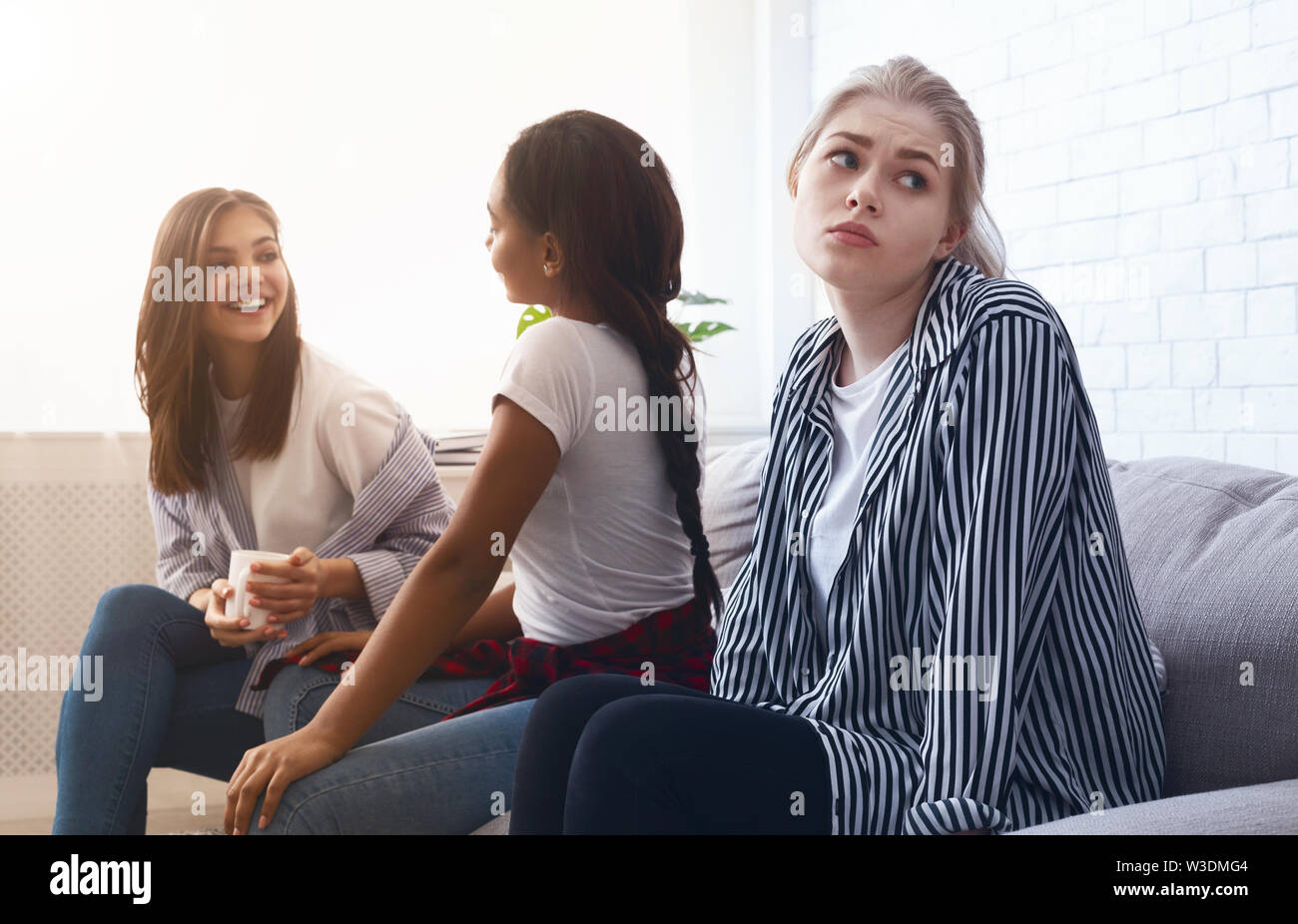 Trauriges Mädchen allein sitzen, vermeiden Sie reden ihren Klassenkameraden Stockfoto