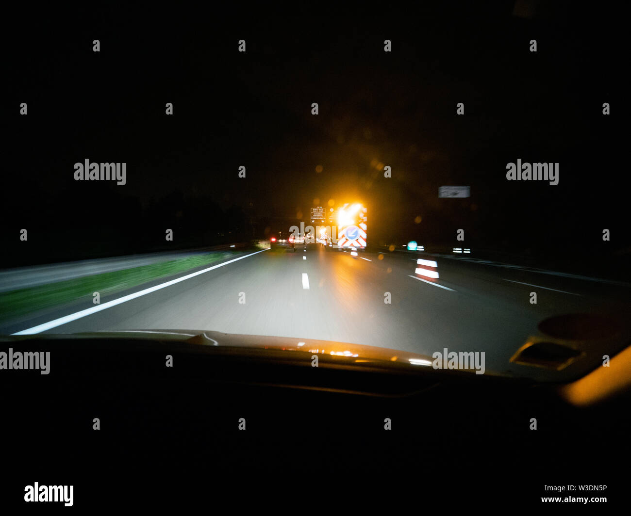 Treiber POV auf der dunklen Autobahn mit Unfall Baustellen und gelb blinkenden Pfeil Stockfoto