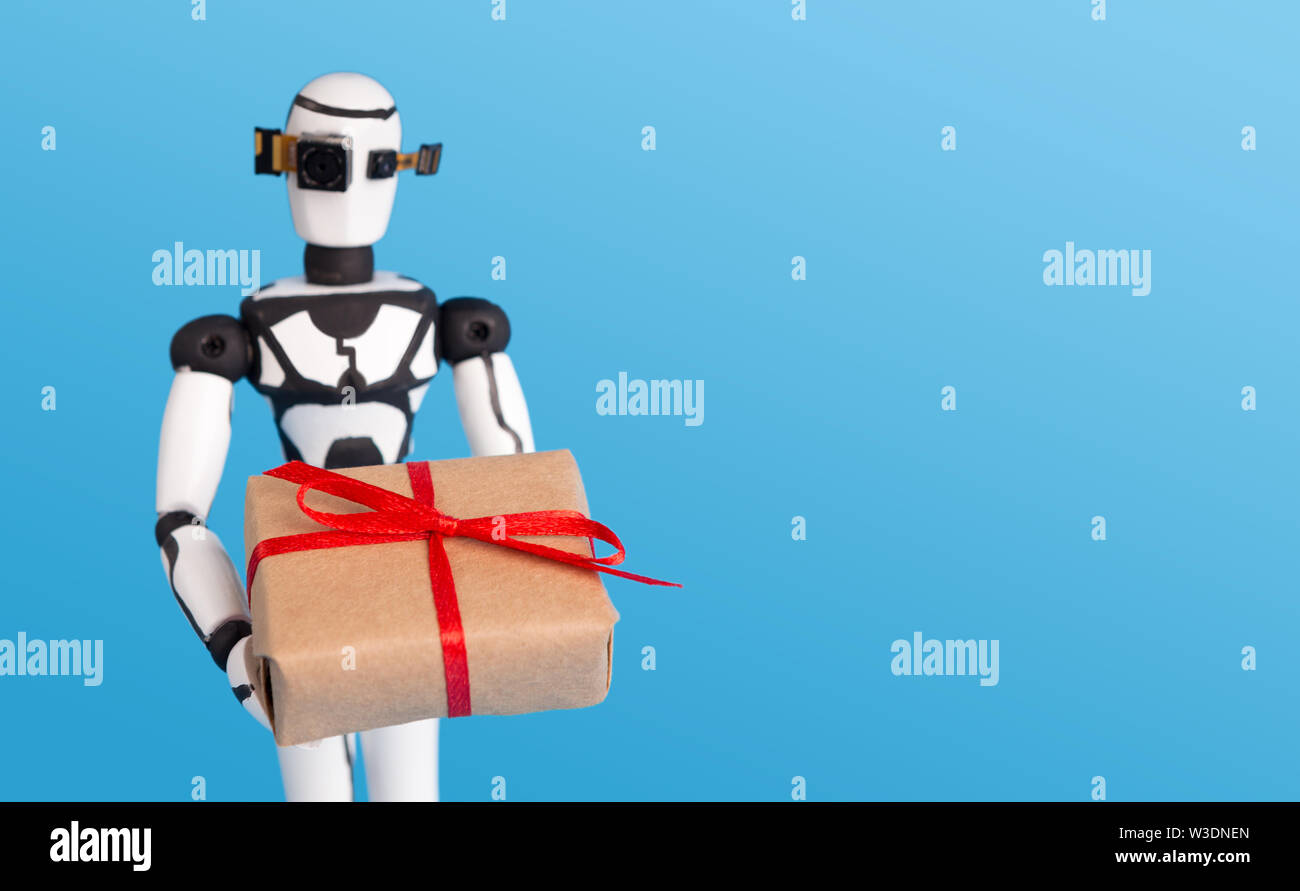 Kleine Roboter, Geschenk, blauer Hintergrund mit leeren Raum. Stockfoto