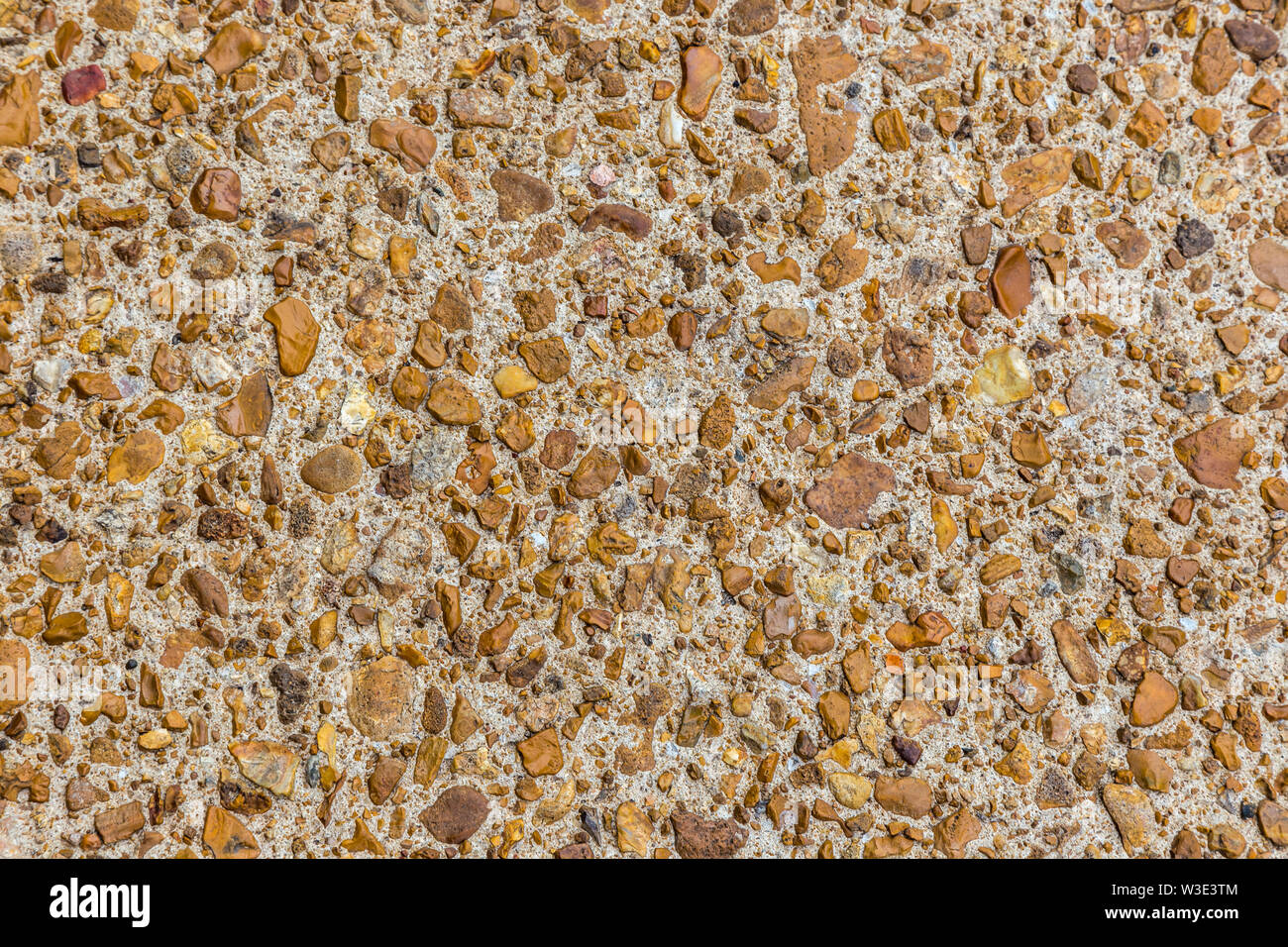 Bunte Steine in Beton auf einen Pfad für eine Textur Hintergrund gesetzt. Stockfoto