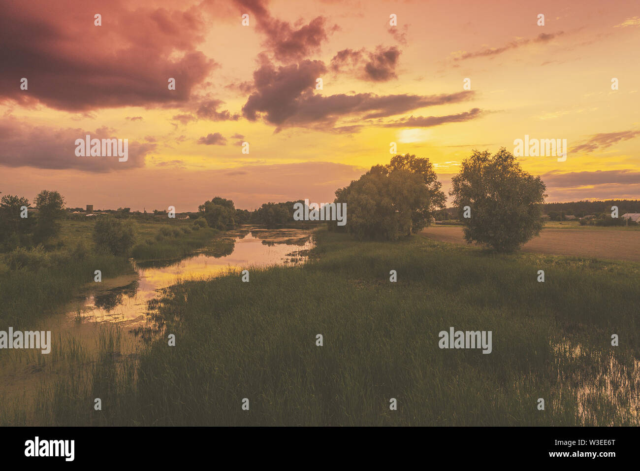 Ein magischer Sonnenuntergang in der Landschaft. Ruhigen Fluss bei Sonnenuntergang. Ländliche Landschaft am Abend. Vogelperspektive Stockfoto