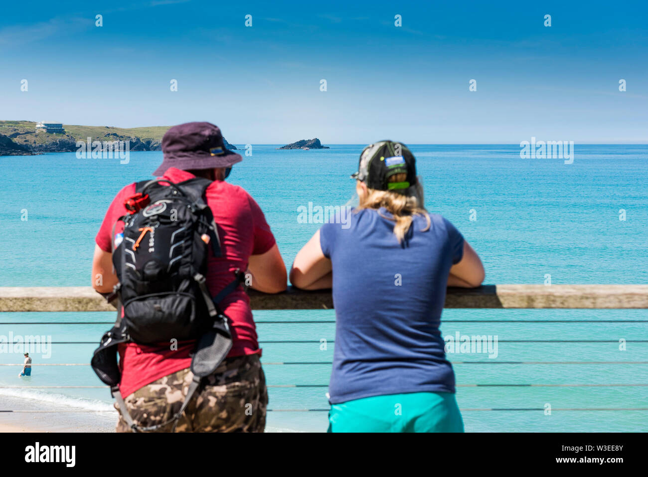 Urlauber, die auf einen Balkon in Richtung Gull Rock Pentire Punkt westlich in Newquay in Cornwall. Stockfoto