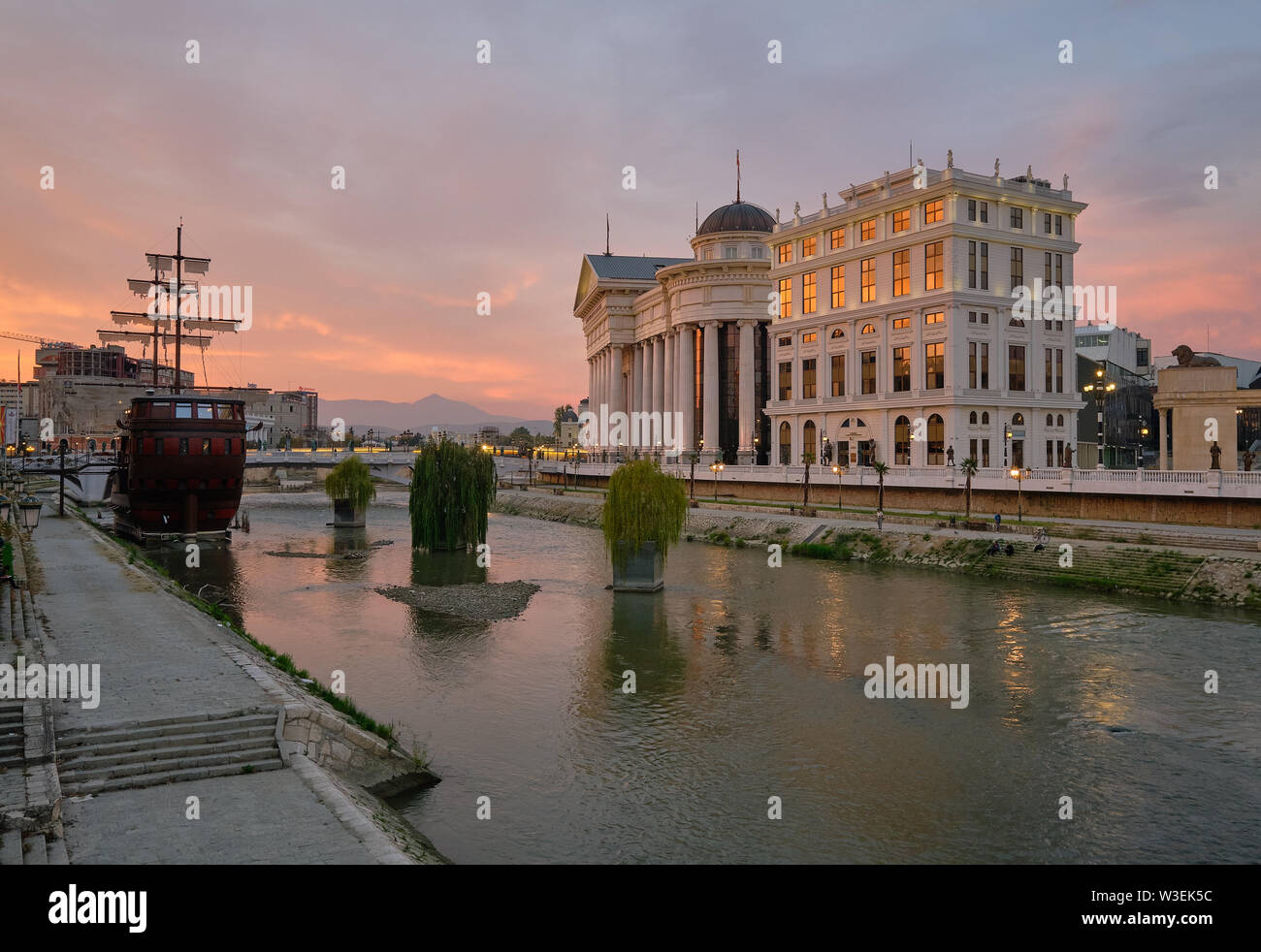Skopje am Fluss bei Sonnenuntergang, mit neuen Konstruktionen gebaut und ein verankertes mast Boot Stockfoto