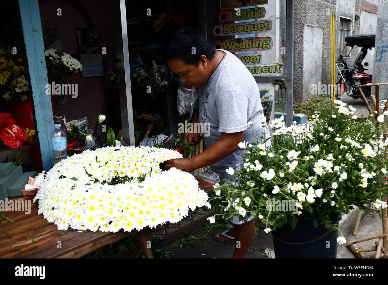 ANTIPOLO CITY, Philippinen - Juli 12, 2019: ein blumengeschäft Arbeiter bereitet einen Blumenstrauß für einen Kunden. Stockfoto