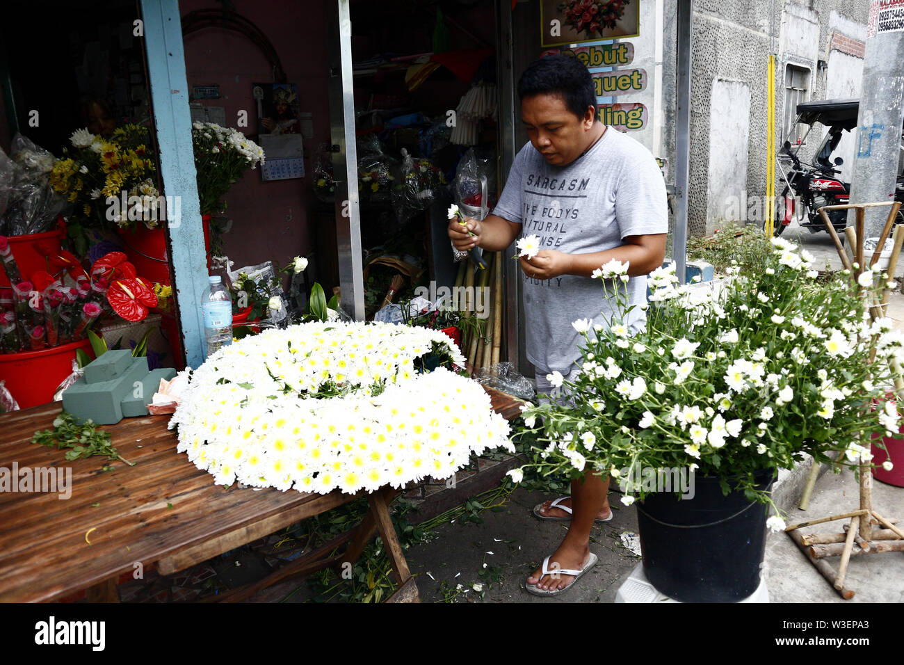 ANTIPOLO CITY, Philippinen - Juli 12, 2019: ein blumengeschäft Arbeiter bereitet einen Blumenstrauß für einen Kunden. Stockfoto