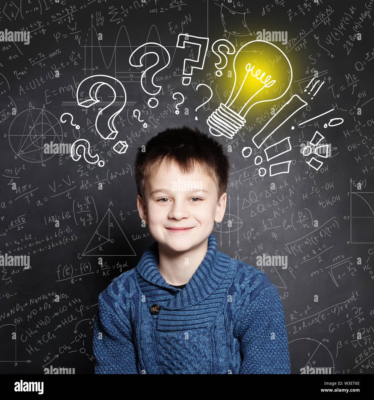 Lächelnd Kind die Schule junge mit Glühbirne auf Hintergrund mit Formeln Stockfoto