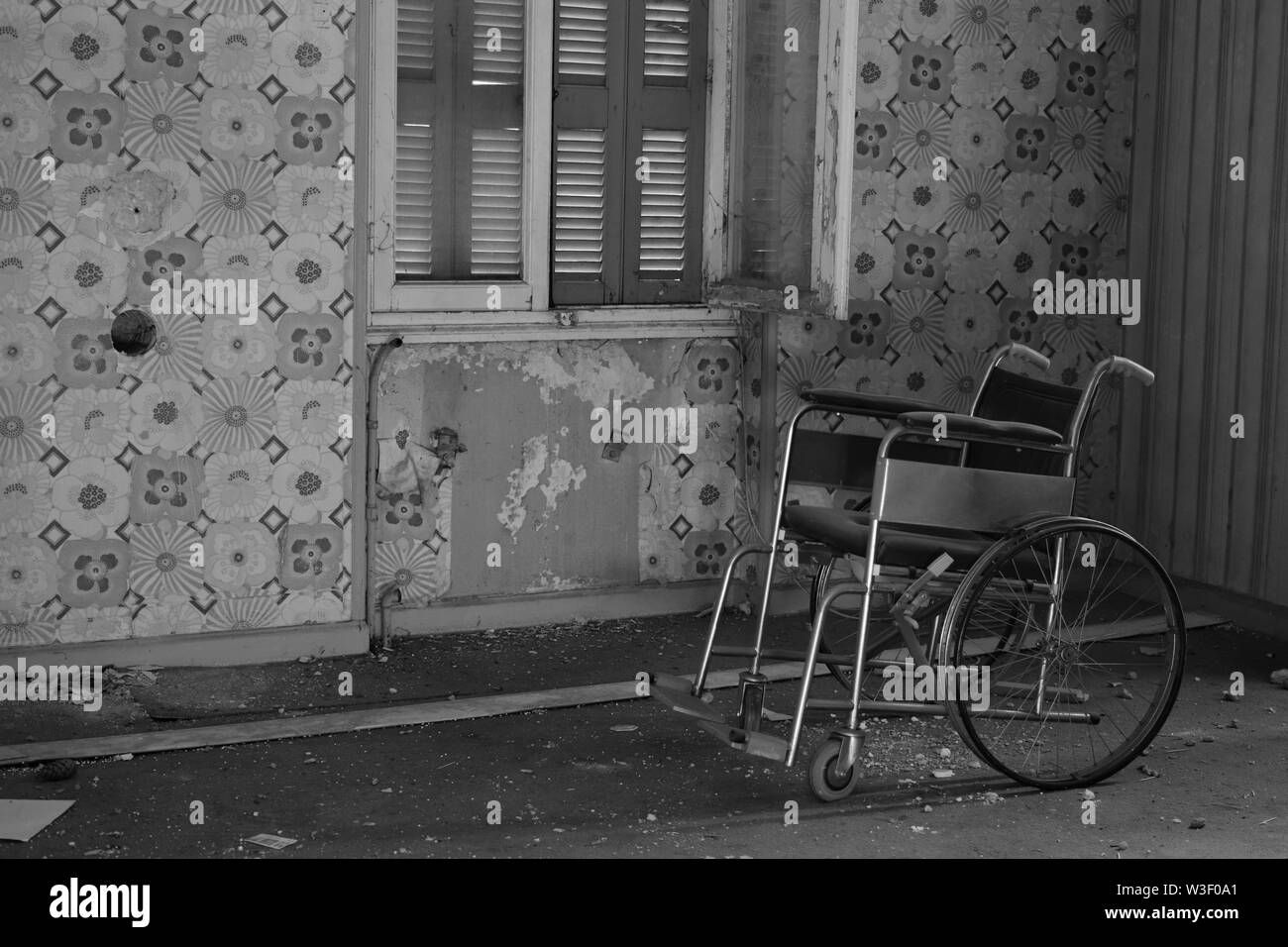 Antike Rollstuhl in verlassenen Haus Interieur. Schwarz und Weiß. Stockfoto