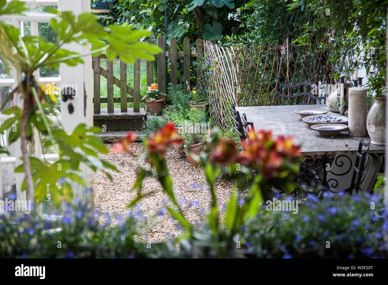 Britische garten Szene, hölzerne Tor, Tisch und Stühle, Stockfoto