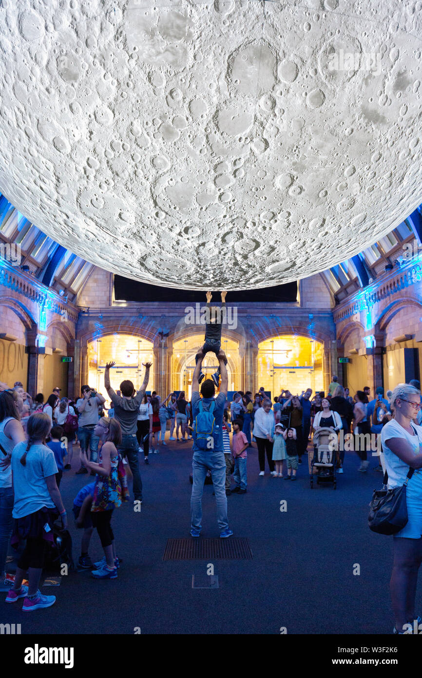 Museum des Mondes - ein Kind berühren der Mond auf einer Ausstellung eines Modells der Mond nach Künstler Luke Jerram; Natural History Museum, London, Großbritannien Stockfoto