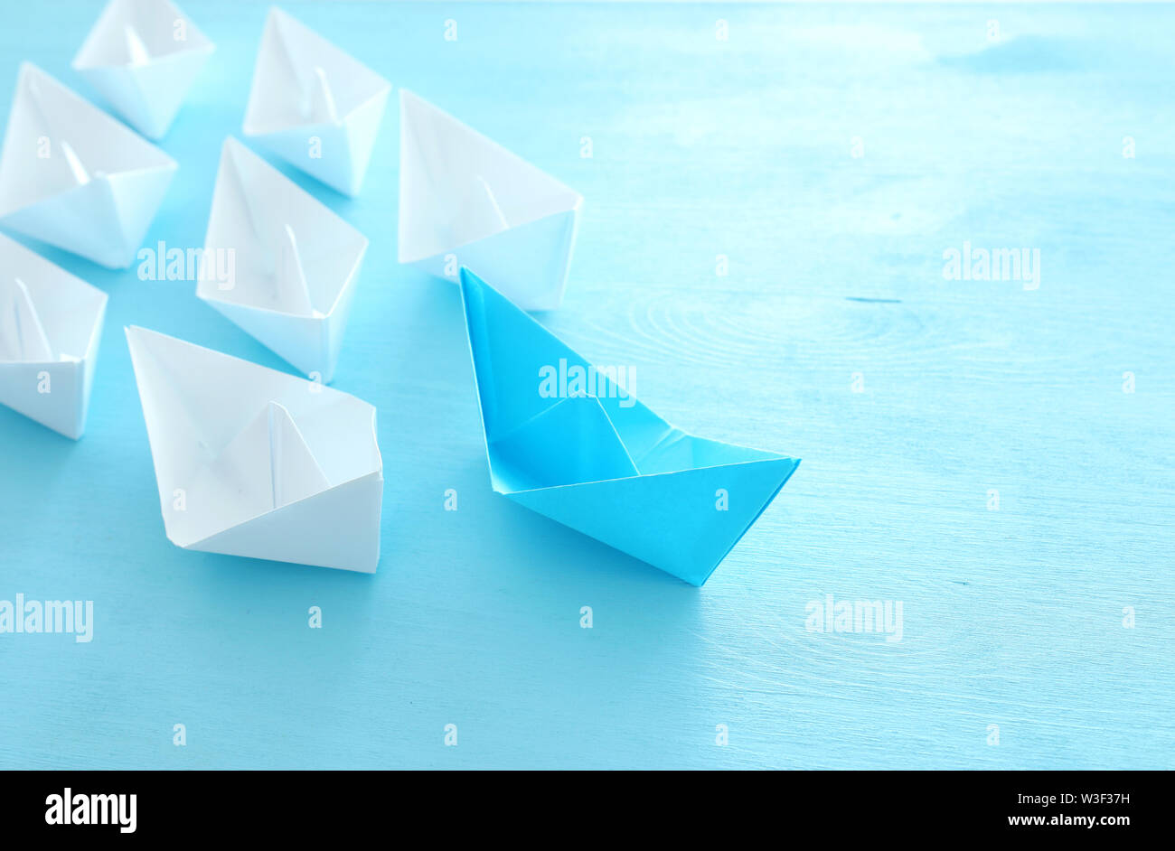 Business. Führung Konzept Bild mit Papier Boote auf Blau Holz- Hintergrund. Ein Führer führen. Stockfoto