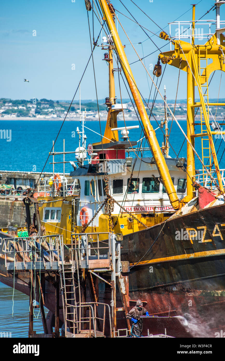 Alte Fischtrawler mit gedrueckt Wasserstrahl auf Newlyn Fischerdorf in der Nähe von Penzance in Cornwall, England, Großbritannien. Stockfoto