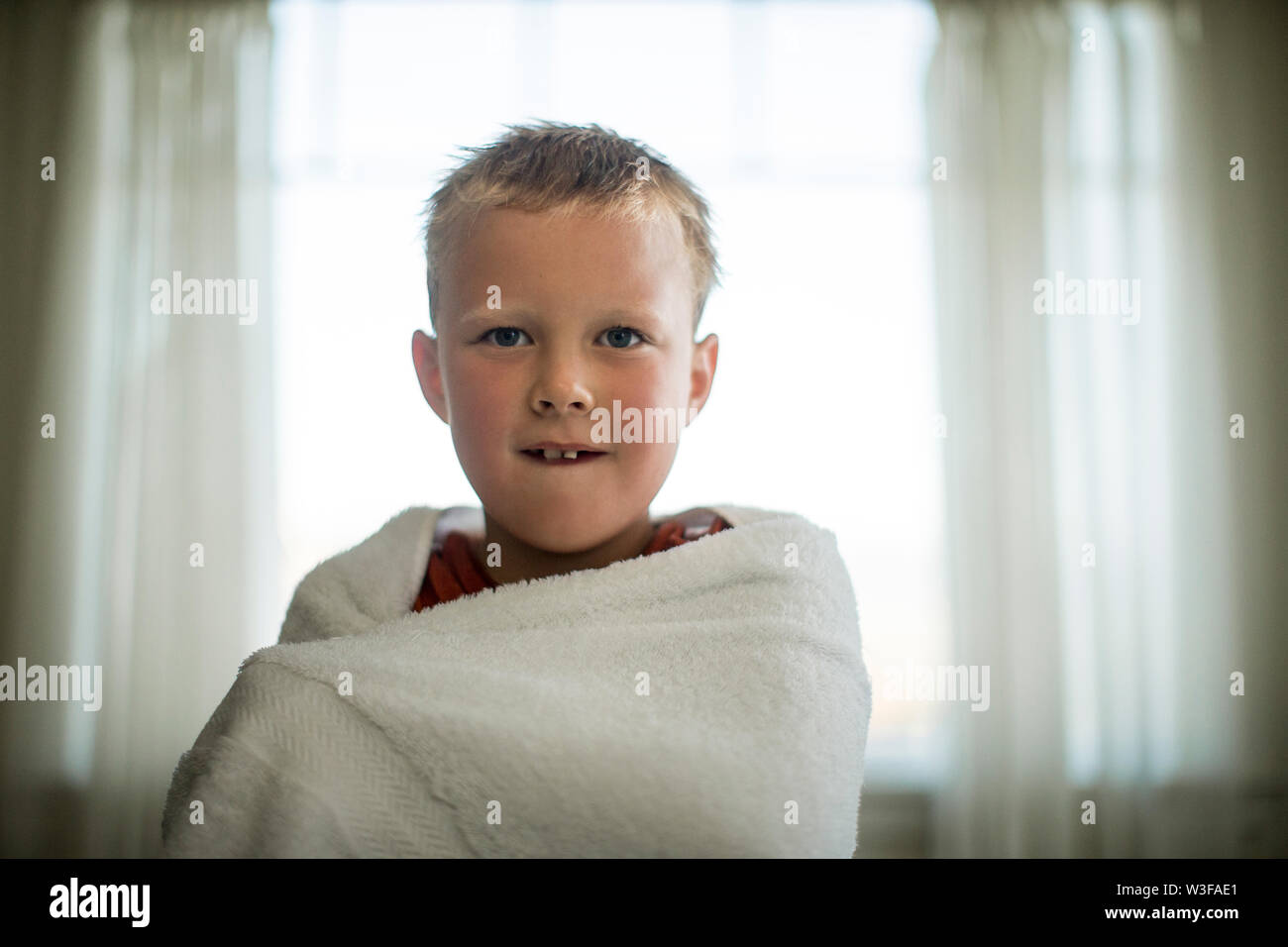 Porträt eines Jungen in ein Handtuch gewickelt. Stockfoto