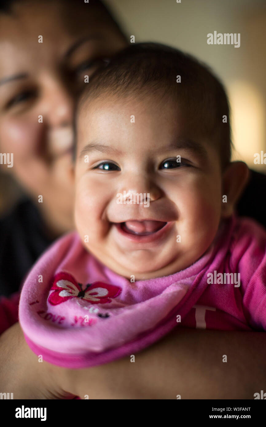 Porträt eines lächelnden Mädchen von ihrer Mutter gehalten wird. Stockfoto