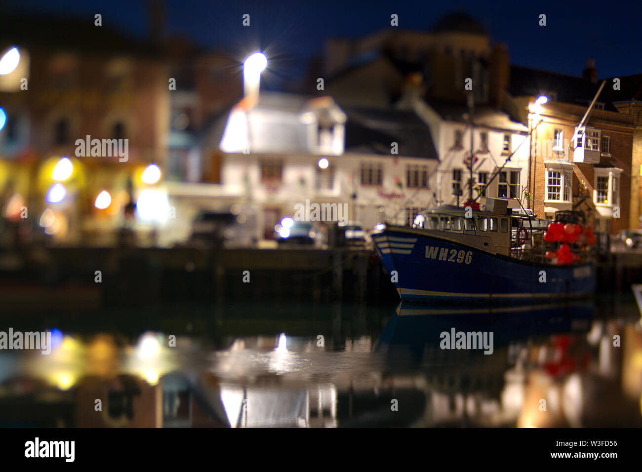 Ein Fischerboot mit orangefarbener, Krabben und Hummer Töpfe, nummerierte WH 296 fotografiert mit einem Lensbaby objektiv in der Nacht neben Weymouth Hafen Dorset Stockfoto