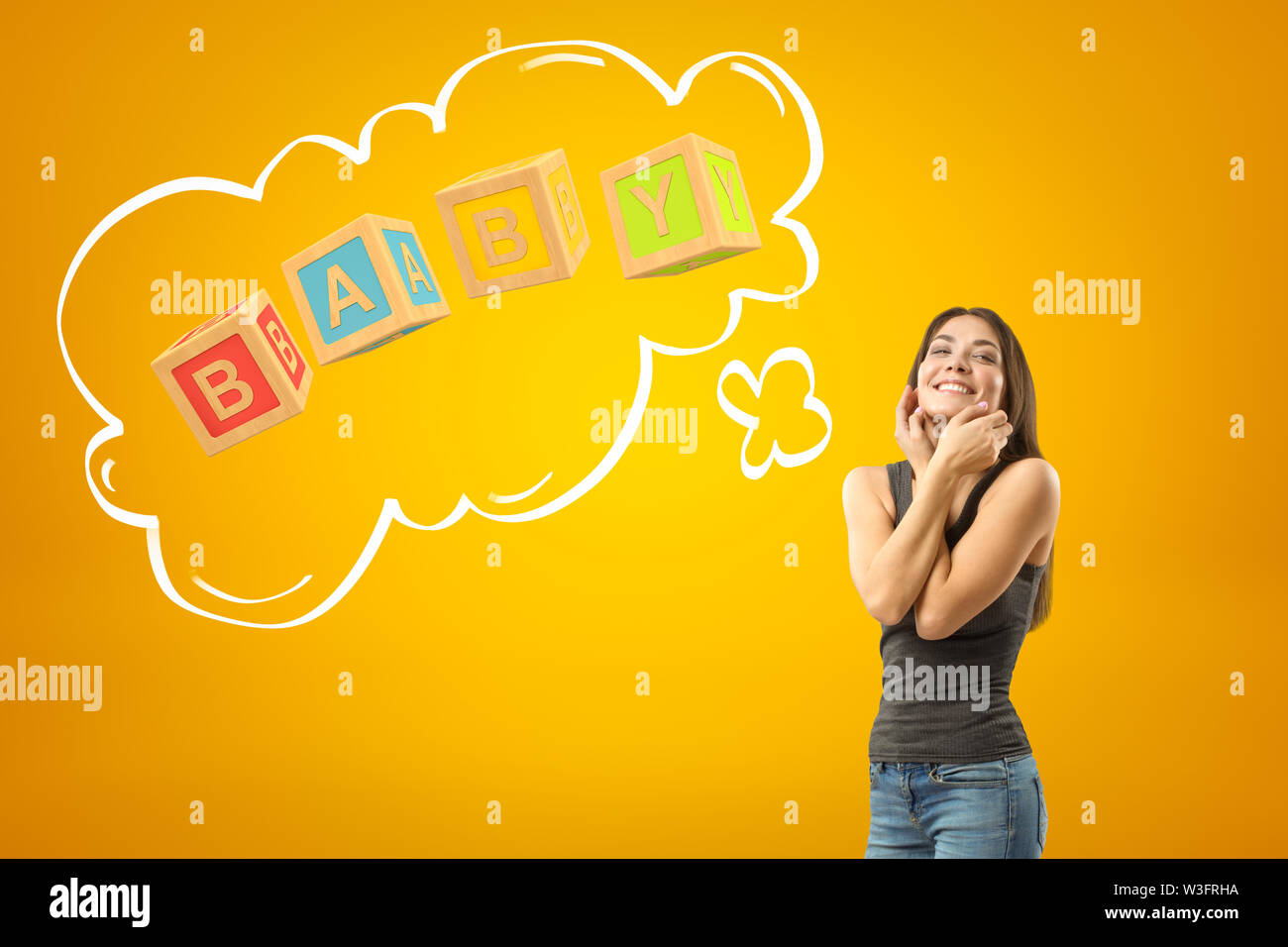 Junge happy brunette Mädchen in Freizeitkleidung mit Baby Spielzeug Bausteine Zeichen auf gelbem Hintergrund Stockfoto