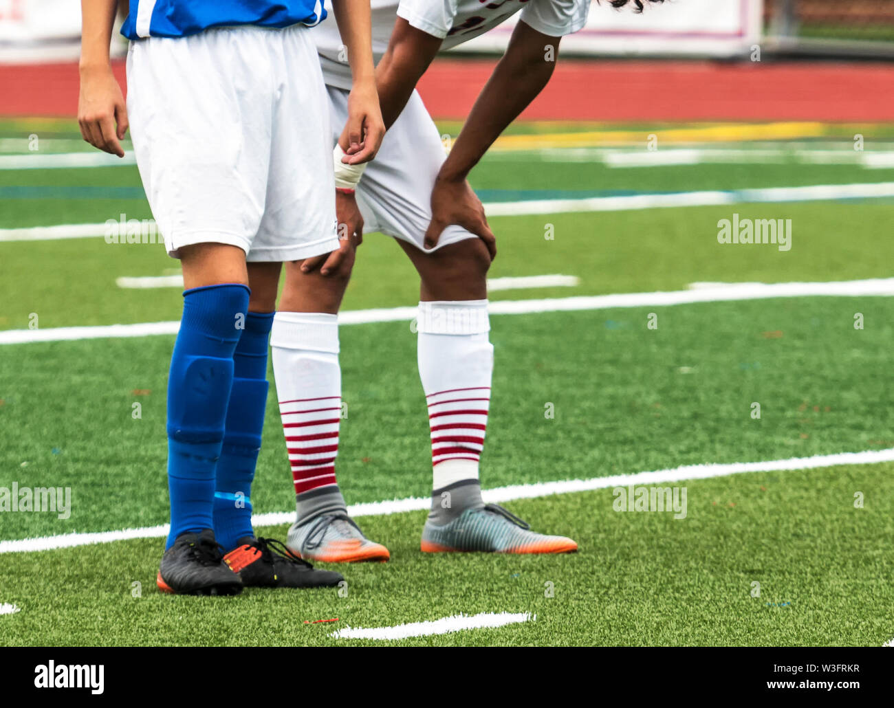 Zwei Fußball-Spieler Nutzen in einem Stillstand im Spiel ihren Atem und Rest zu fangen. Stockfoto