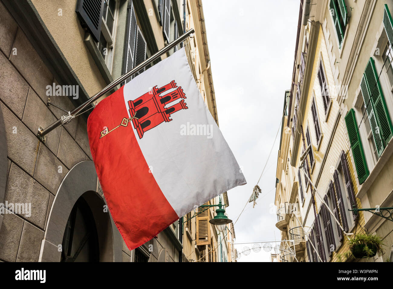 Gibraltar, Großbritannien. Flagge Gibraltar winkt von einem der Häuser in der Hauptstraße. Ein britisches Überseegebiet von Spanien umstrittenen Stockfoto