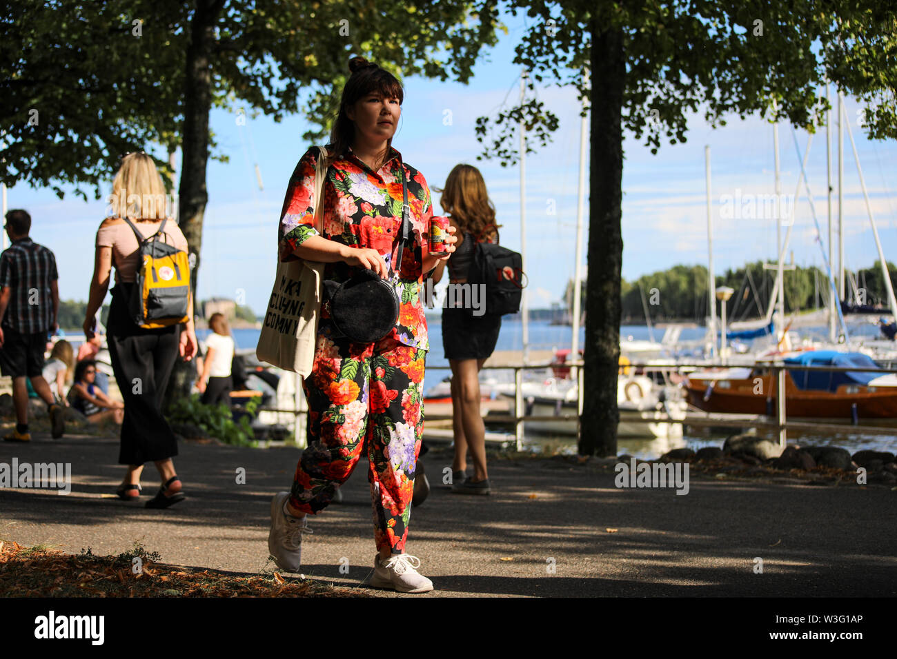 Junge Frau im Sommer Tücher mit einem passenden kann der sider Merihaka am Meer entlang spazieren während Kallio Block Party 2018 in Helsinki, Finnland Stockfoto