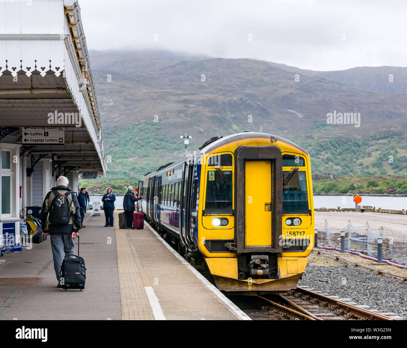 ScotRail tran an Plattform, Kyle von Lochalsh entfernt, und die Fluggäste mit Koffern, Schottland, Großbritannien Stockfoto