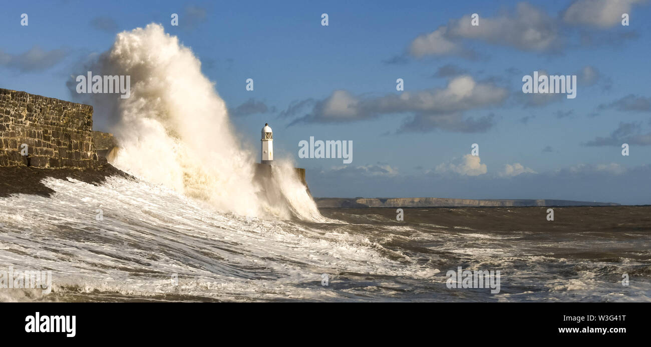 PORTHCAWL, WALES - Oktober 2018: die Wellen gegen die Hafenmauer in der Abendsonne bei Flut in Porthcawl, Wales. Stockfoto