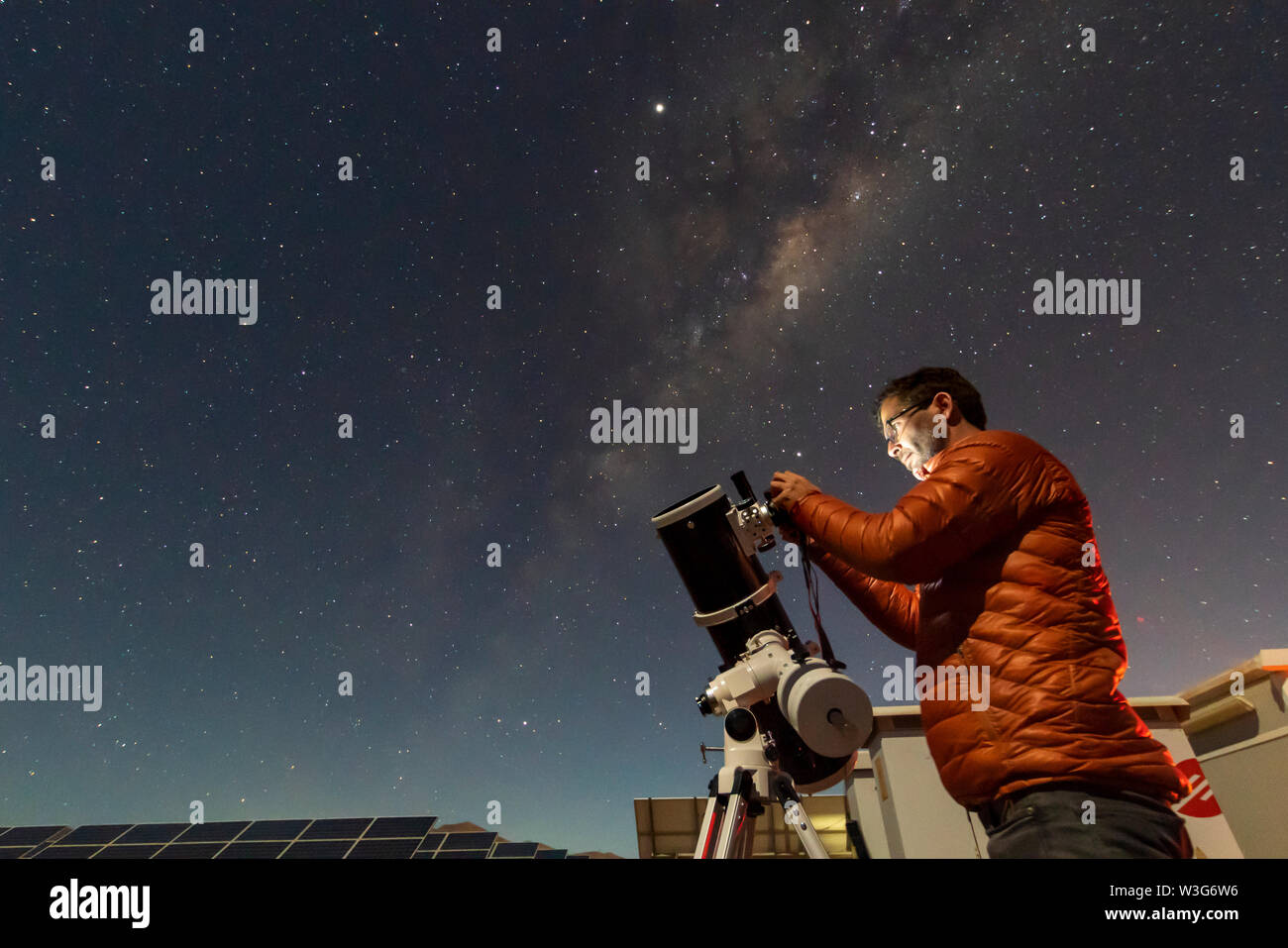 Ein Astronom schaut durch ein Amateurteleskop auf den Nachthimmel und fotografiert mit der Milchstraße, die den Horizont aufsteigt, ein erstaunlicher Nachthimmel Stockfoto