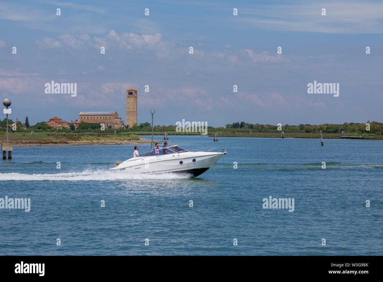 Weiß Schnellboot Beschleunigung von Torcello, einer kleinen Insel in der Lagune von Venedig, Italien: Blick auf die Kathedrale Santa Maria Assunta, Santa Fosca und Campanile Stockfoto