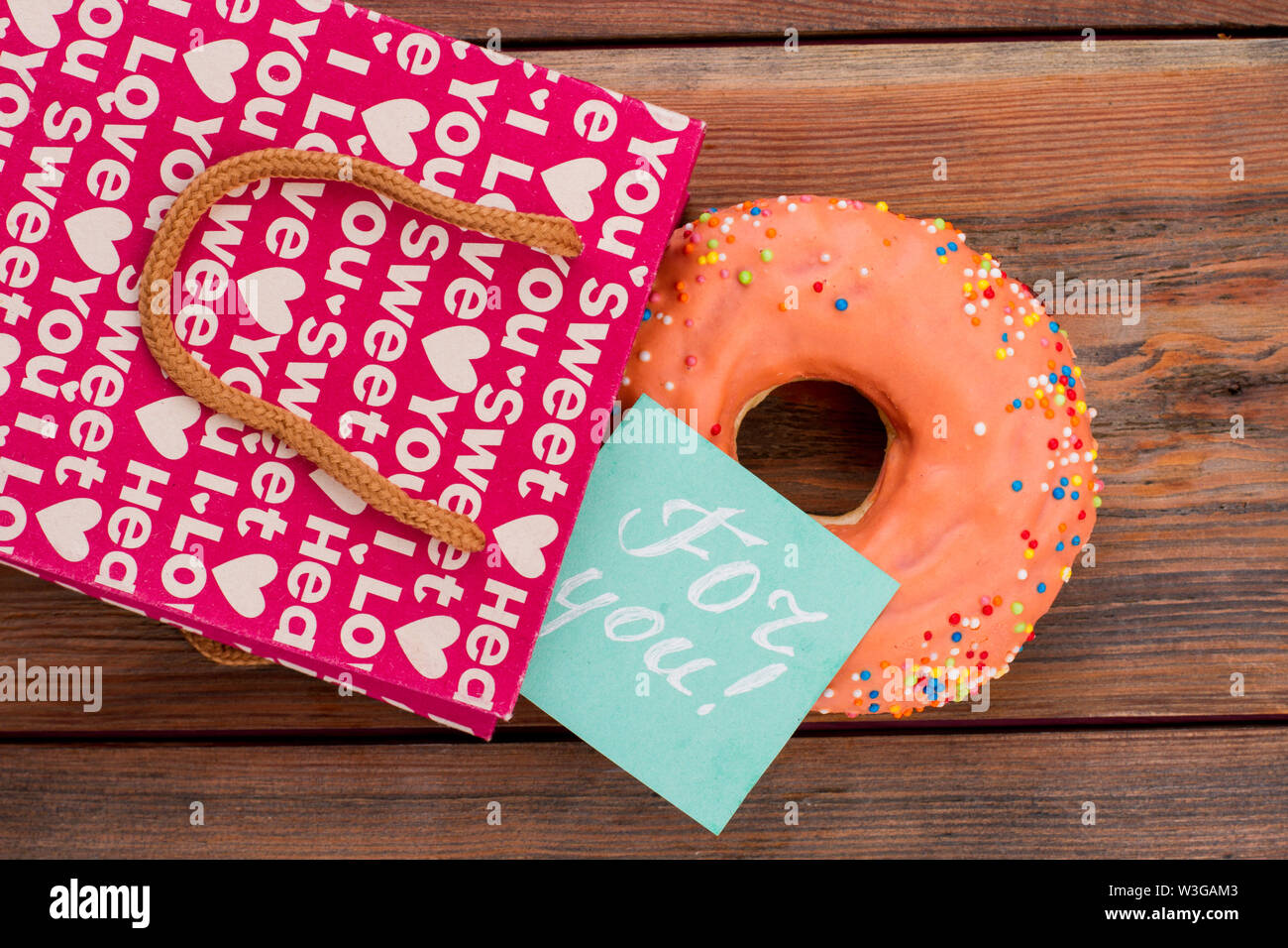 Eisdonut, Geschenktüte und Nachricht. Stockfoto
