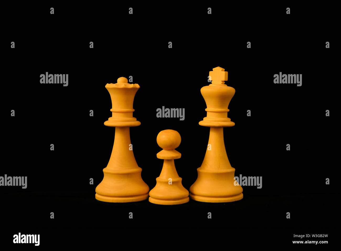 Weiße König, Dame und Bauern als ein Kind Familie Konzept. Drei Standard Schach Holzteile auf schwarzem Hintergrund Stockfoto